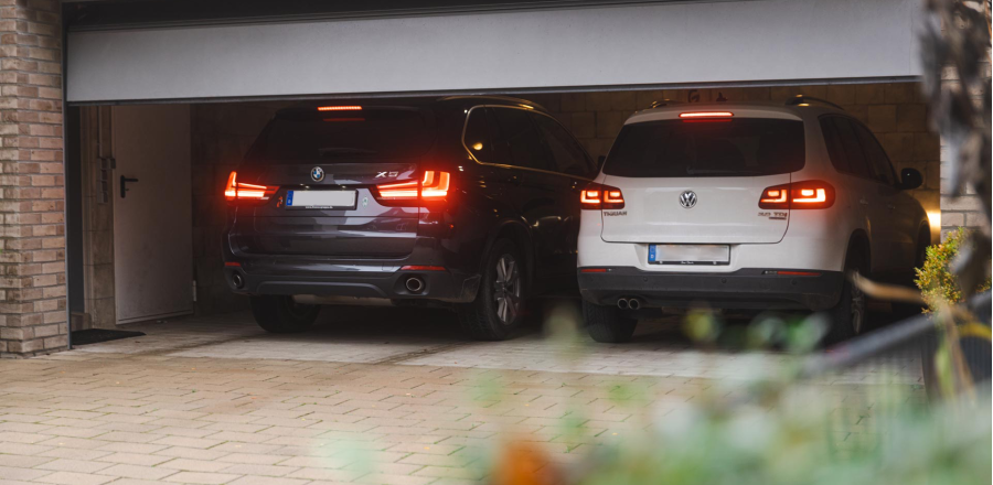 2 autos in einer Garage mit offenem Garagentor